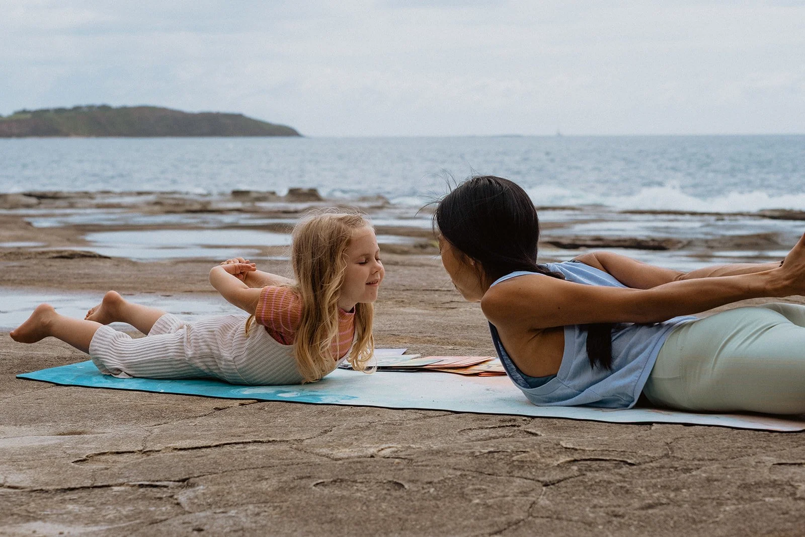 Catherine Tong sharing yoga with a child by the ocean