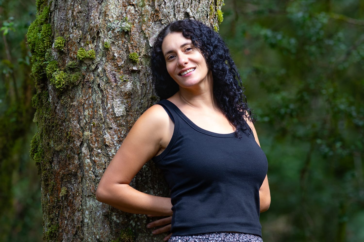 Mel smiling beside a tree